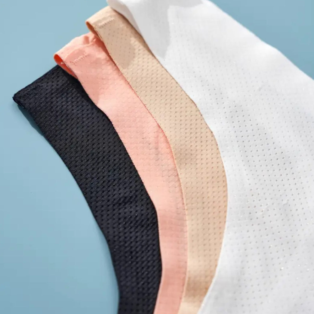 Four pieces of mesh fabric in black, pink, beige, and white on a light blue background.