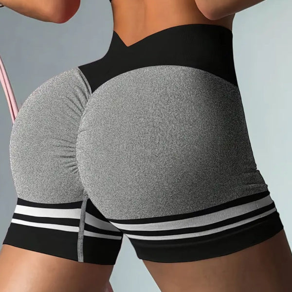 Gray and black athletic shorts with white stripes on a gray background