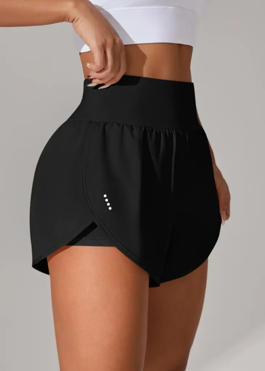 Black athletic shorts worn by a person on a gray background