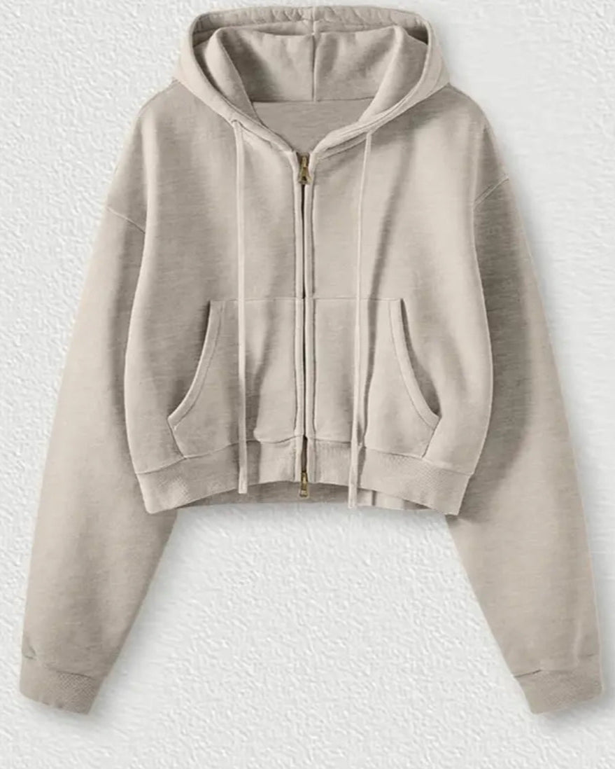Beige hoodie with a zipper on a textured white background
