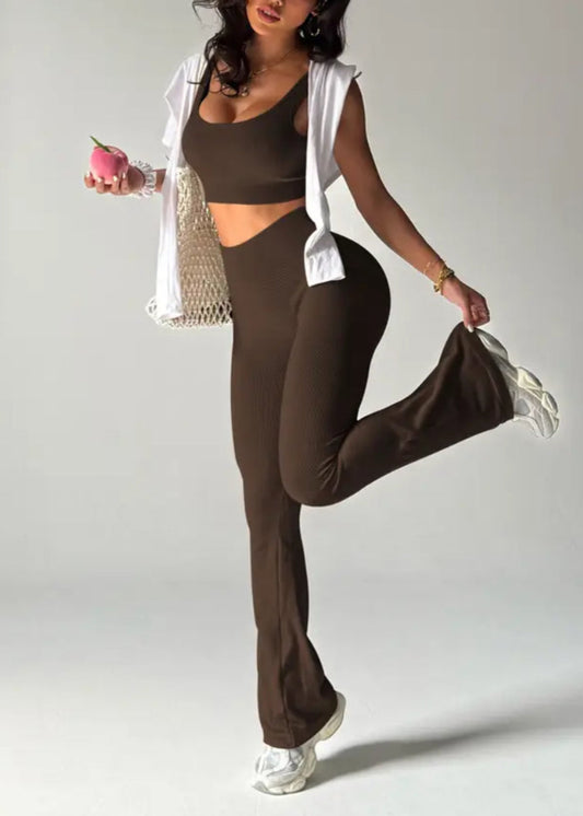 Woman in brown athletic wear posing with a pink apple on a gray background