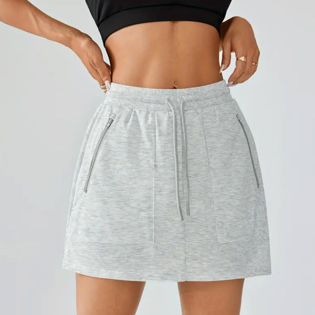 Gray skirt worn by a person on a plain background