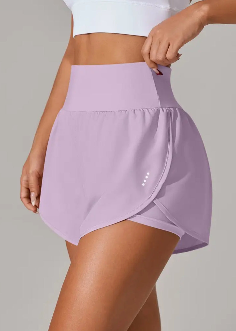 Person wearing a light purple athletic skirt on a plain background