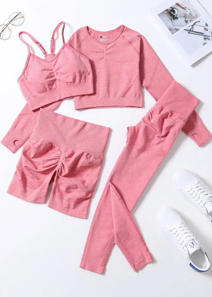 Pink athletic wear set on a white surface with sneakers and glasses.