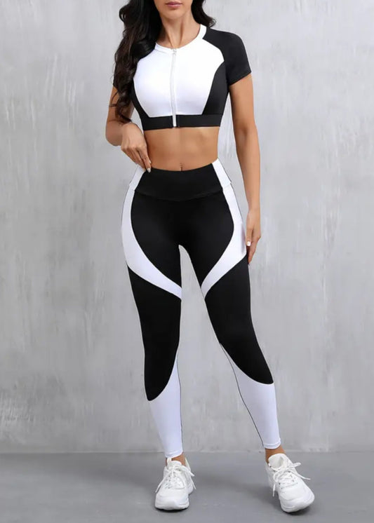 Woman wearing a black and white athletic outfit against a gray background