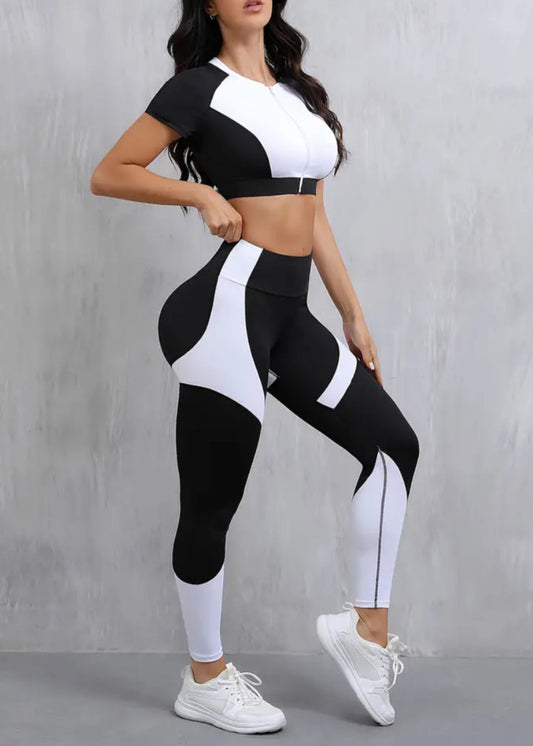 Woman wearing a black and white athletic outfit on a gray background