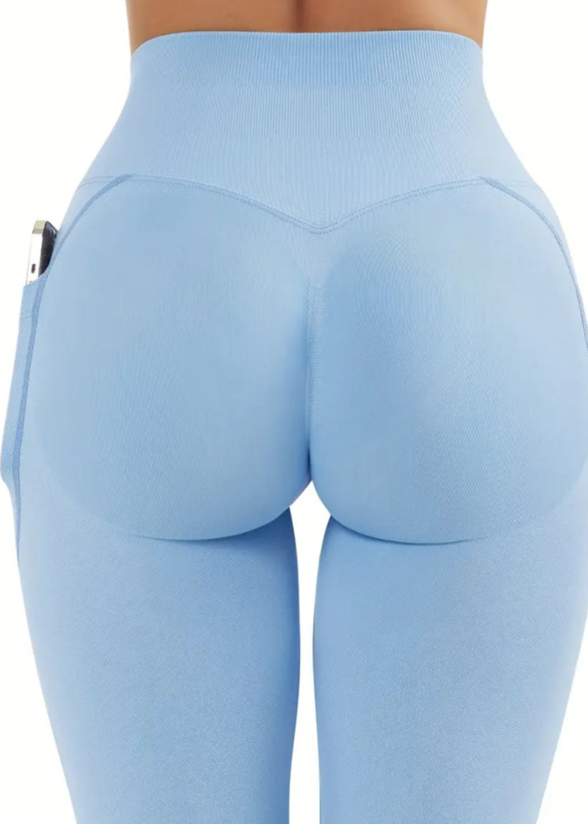 Light blue leggings with a high waist and side pockets on a white background