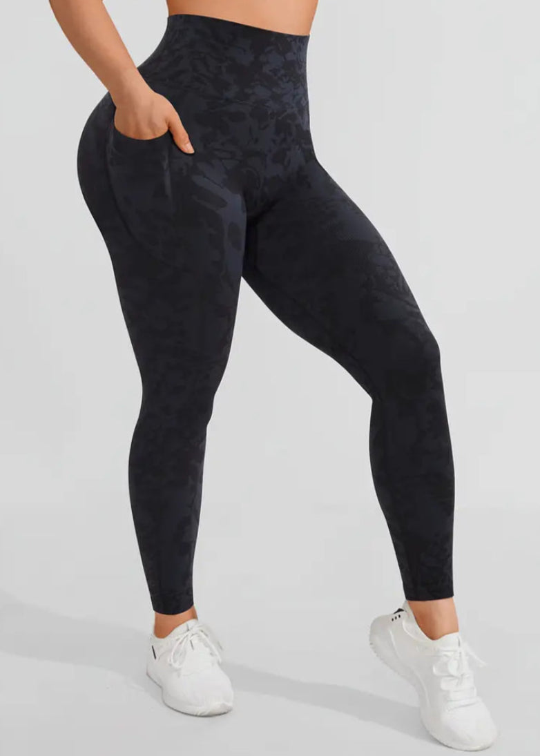 Person wearing black leggings and white sneakers on a light gray background