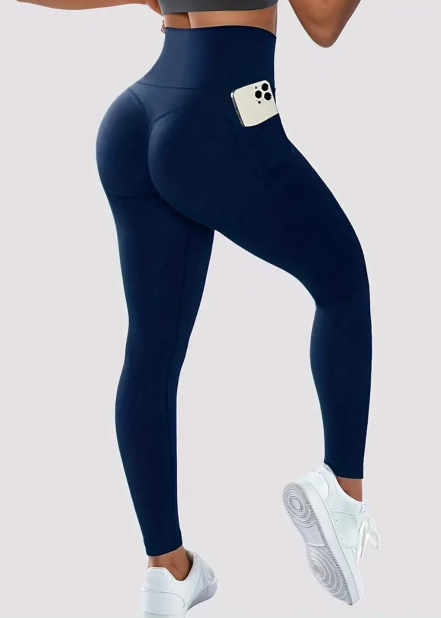 Navy blue leggings with a pocket on a light gray background